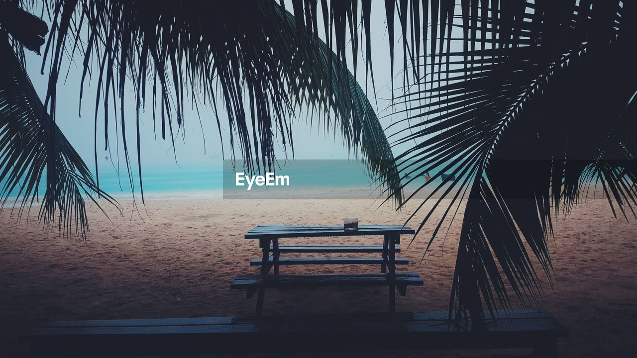 Empty bench overlooking calm sea