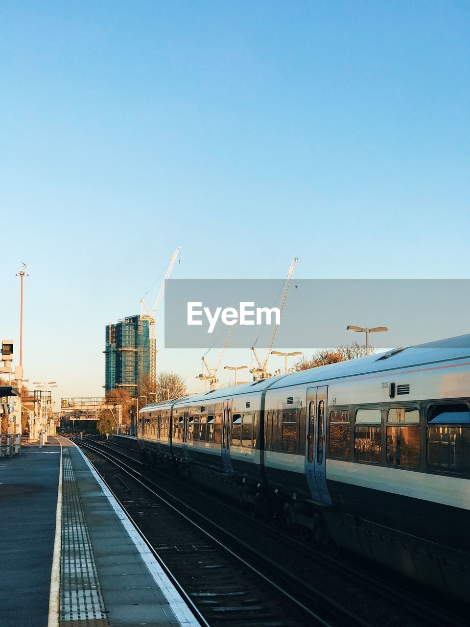 Train at railroad station against clear blue sky