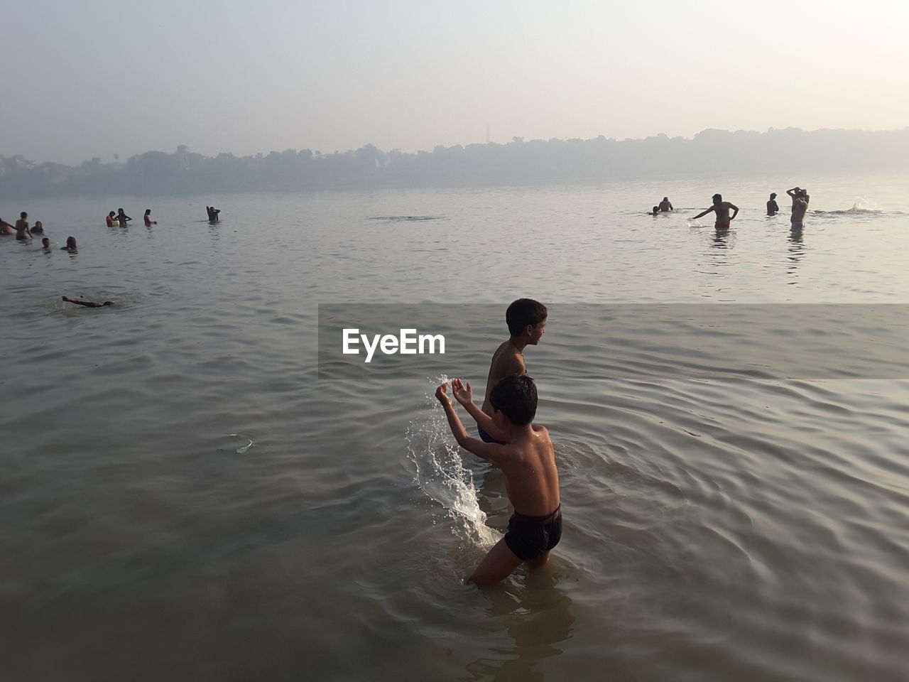 PEOPLE ENJOYING IN SEA AGAINST SKY