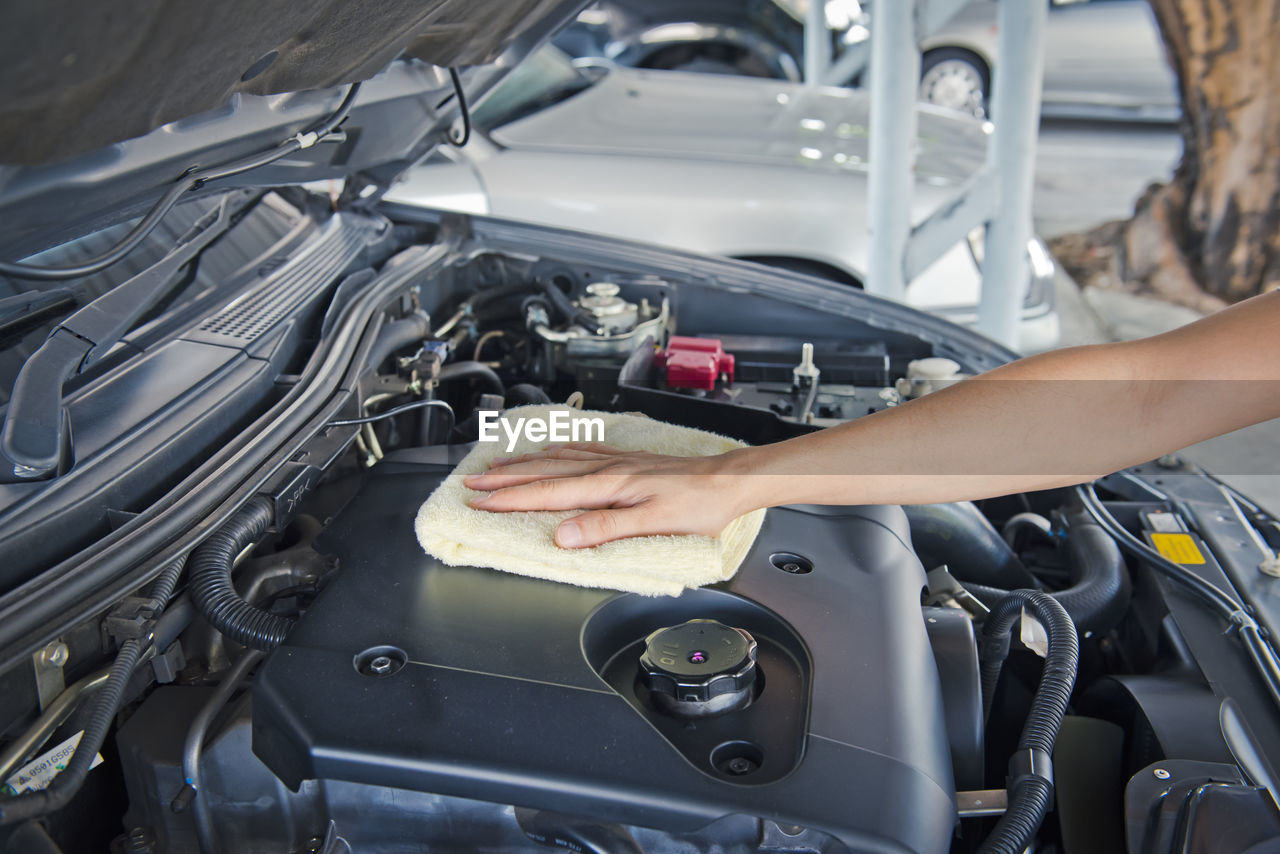 Hand cleaning car engine with a rag,worker
