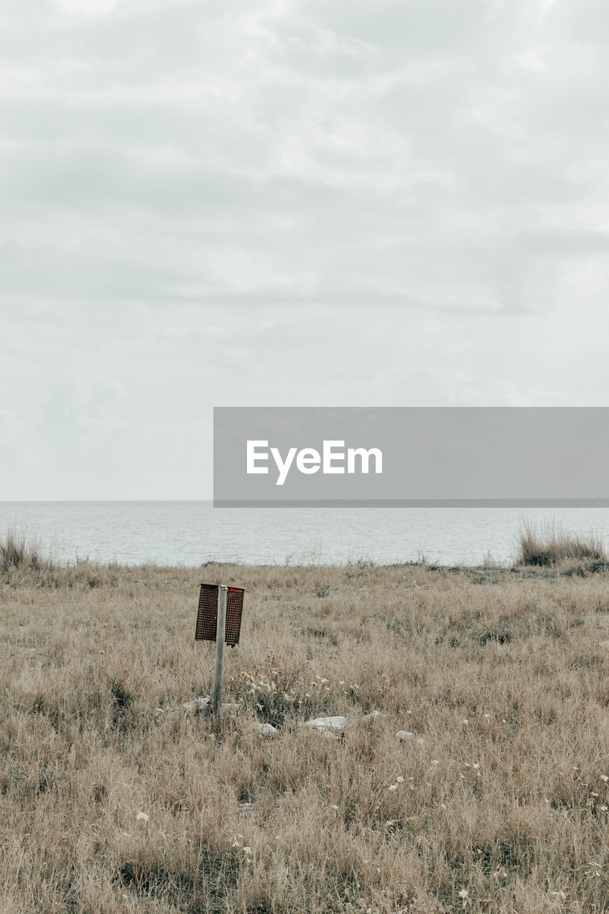 LIFEGUARD HUT ON FIELD AGAINST SKY