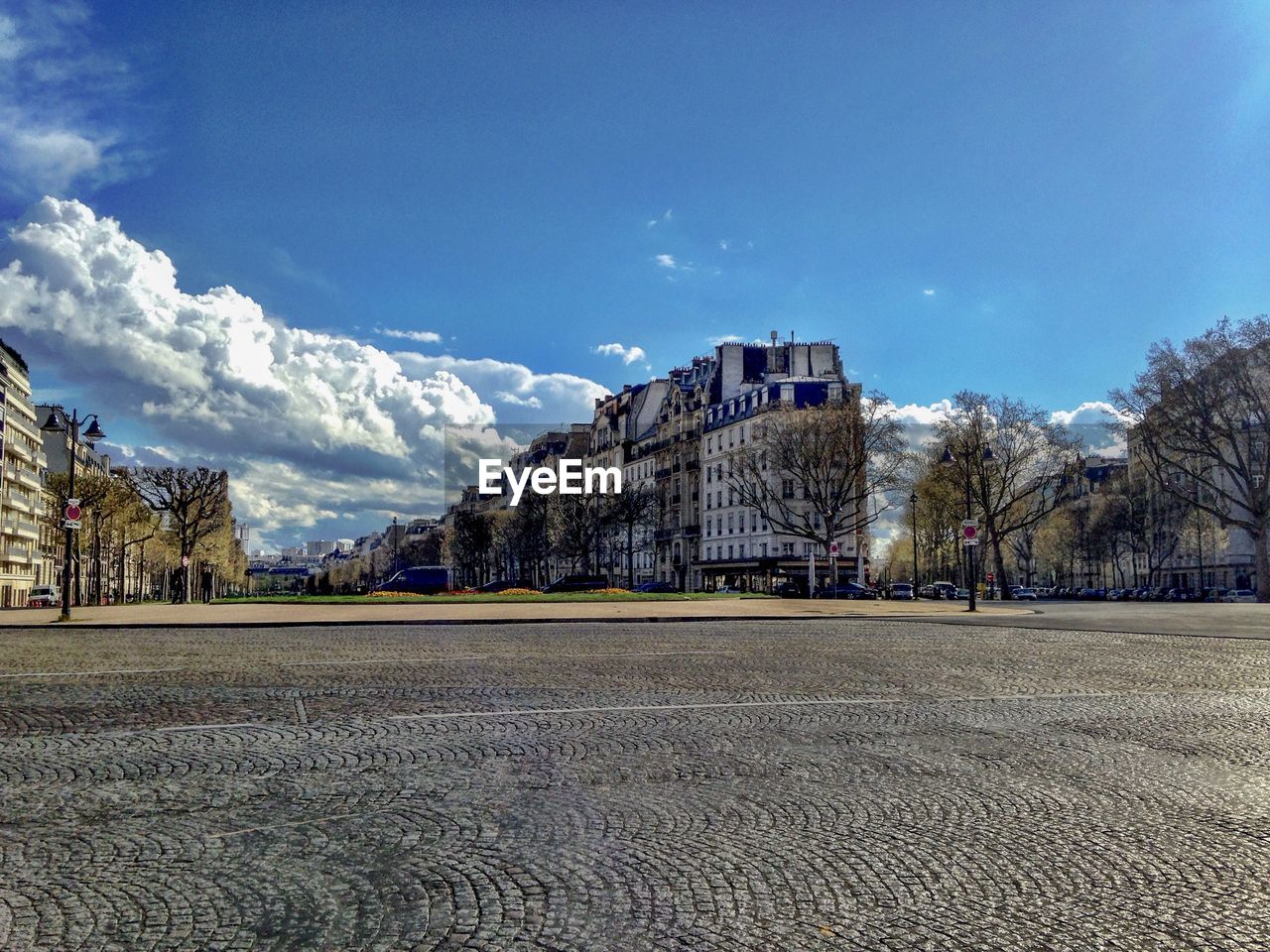 Road by buildings against sky in city