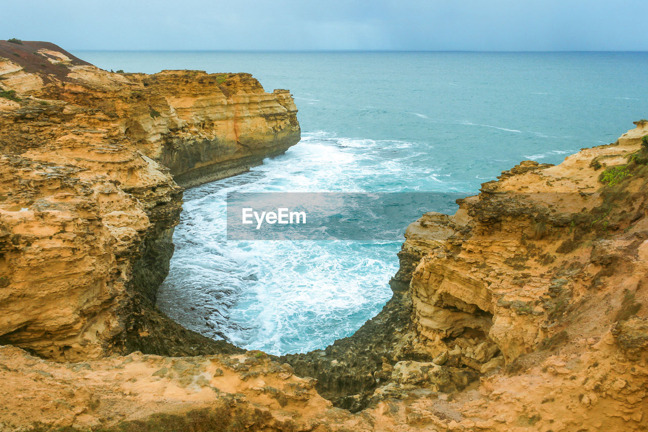 Scenic view of cliff by sea