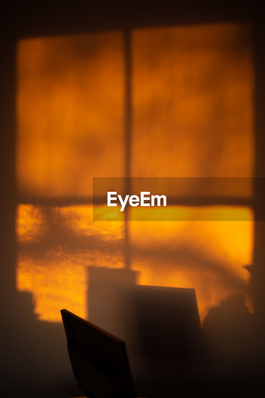 Warm orange light from sunrise reflected on a kitchen office during lockdown in london, uk