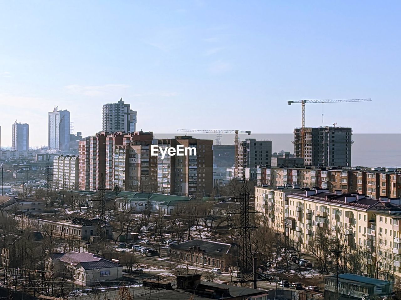 Buildings in city against clear blue sky