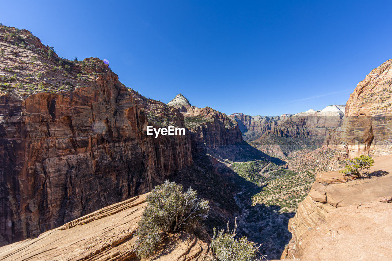 low angle view of rock formations against clear blue sky