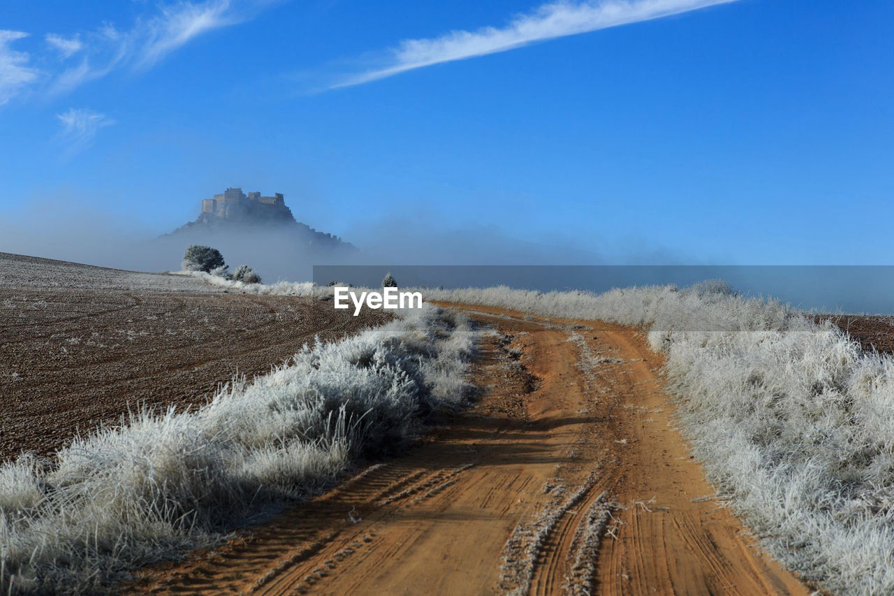 Panoramic view of dirt road against sky