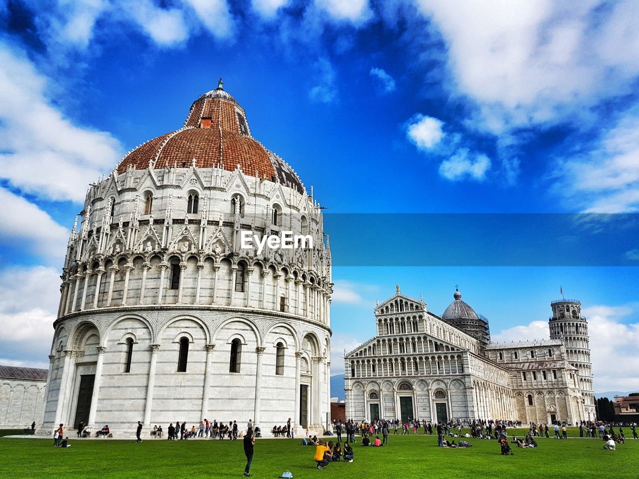 People at piazza dei miracoli against blue sky