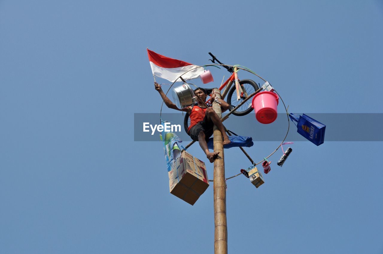 LOW ANGLE VIEW OF RED BALLOONS AGAINST CLEAR BLUE SKY