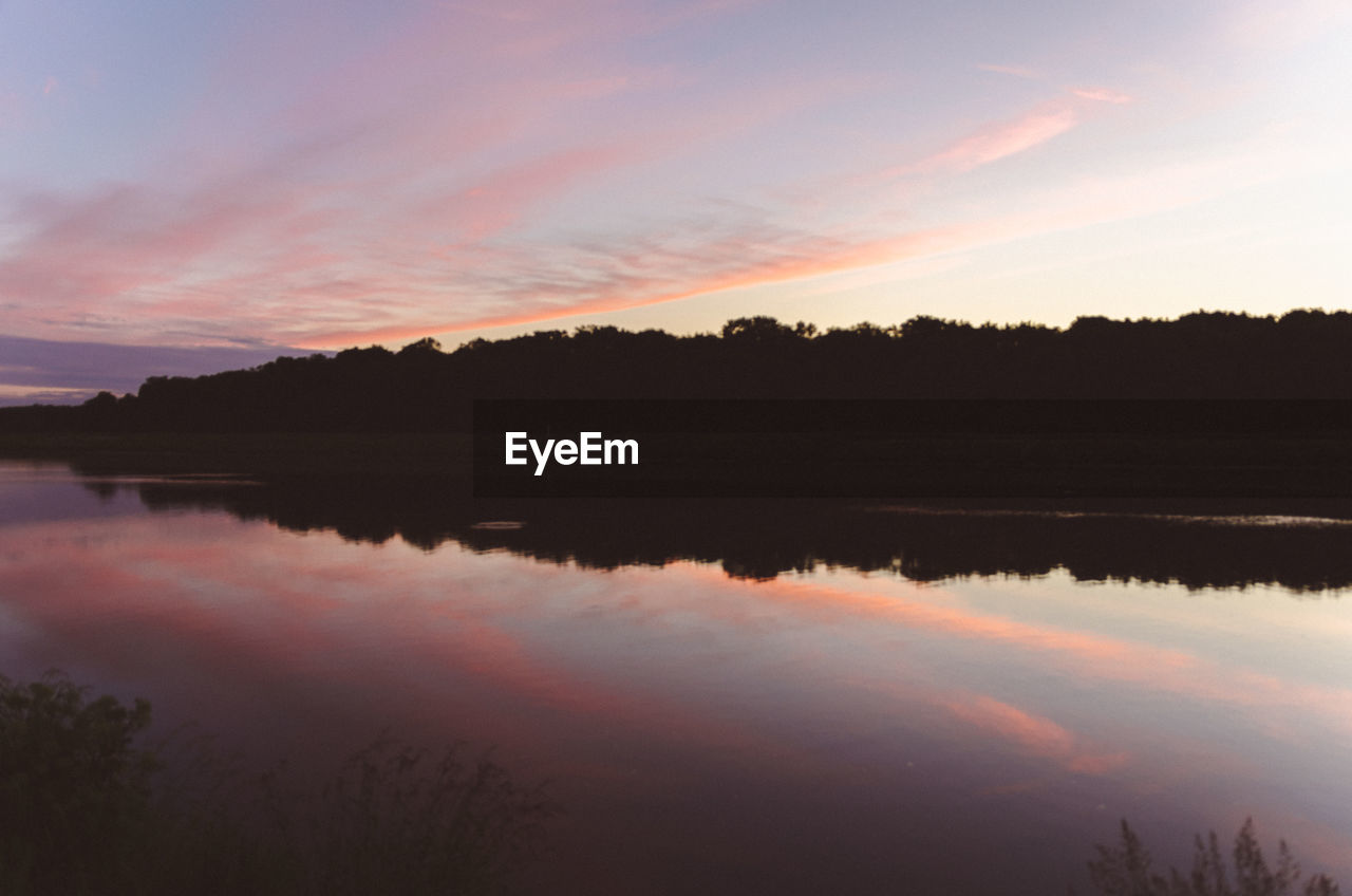 Scenic view of lake against sky at sunset