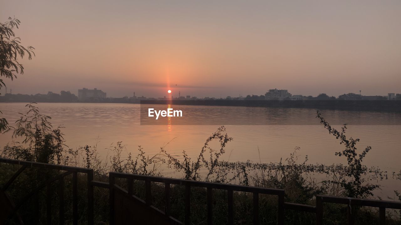 SCENIC VIEW OF LAKE AGAINST ORANGE SKY DURING SUNSET