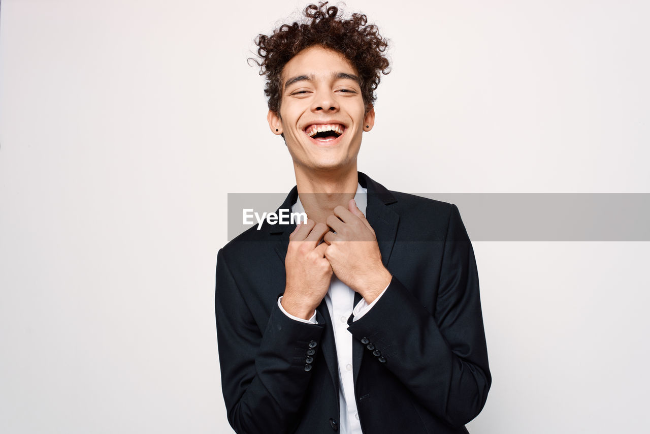 Portrait of smiling man standing against white background