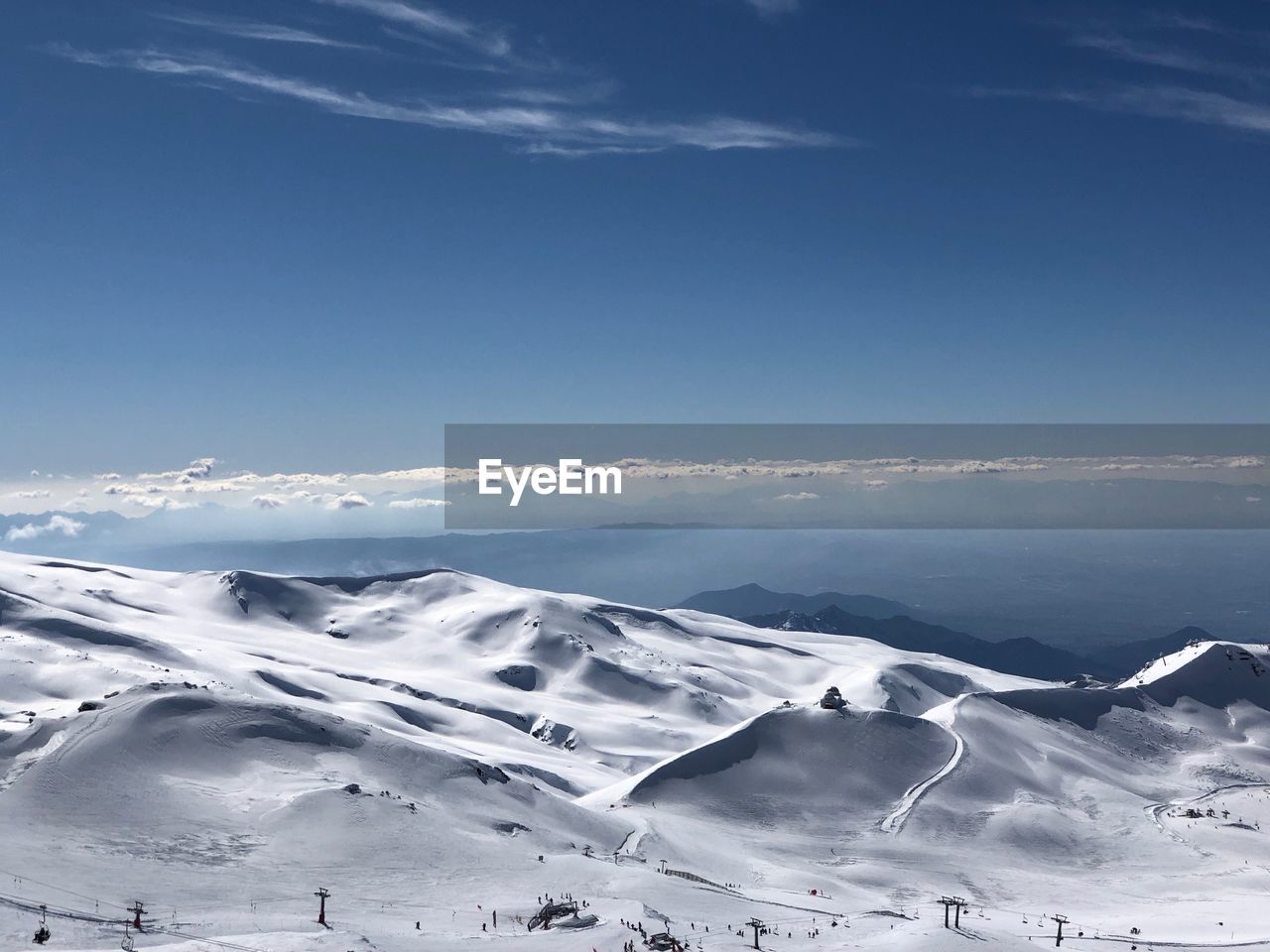 Scenic view of snowcapped mountains against blue sky