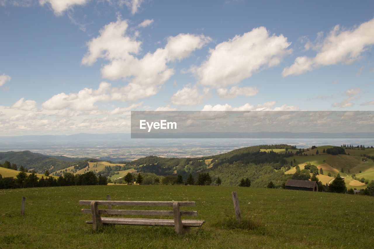 Scenic view of field and mountains against sky