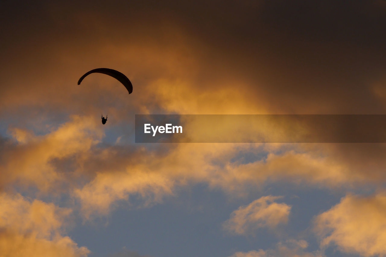 Silhouette of a paraglider at sunset.