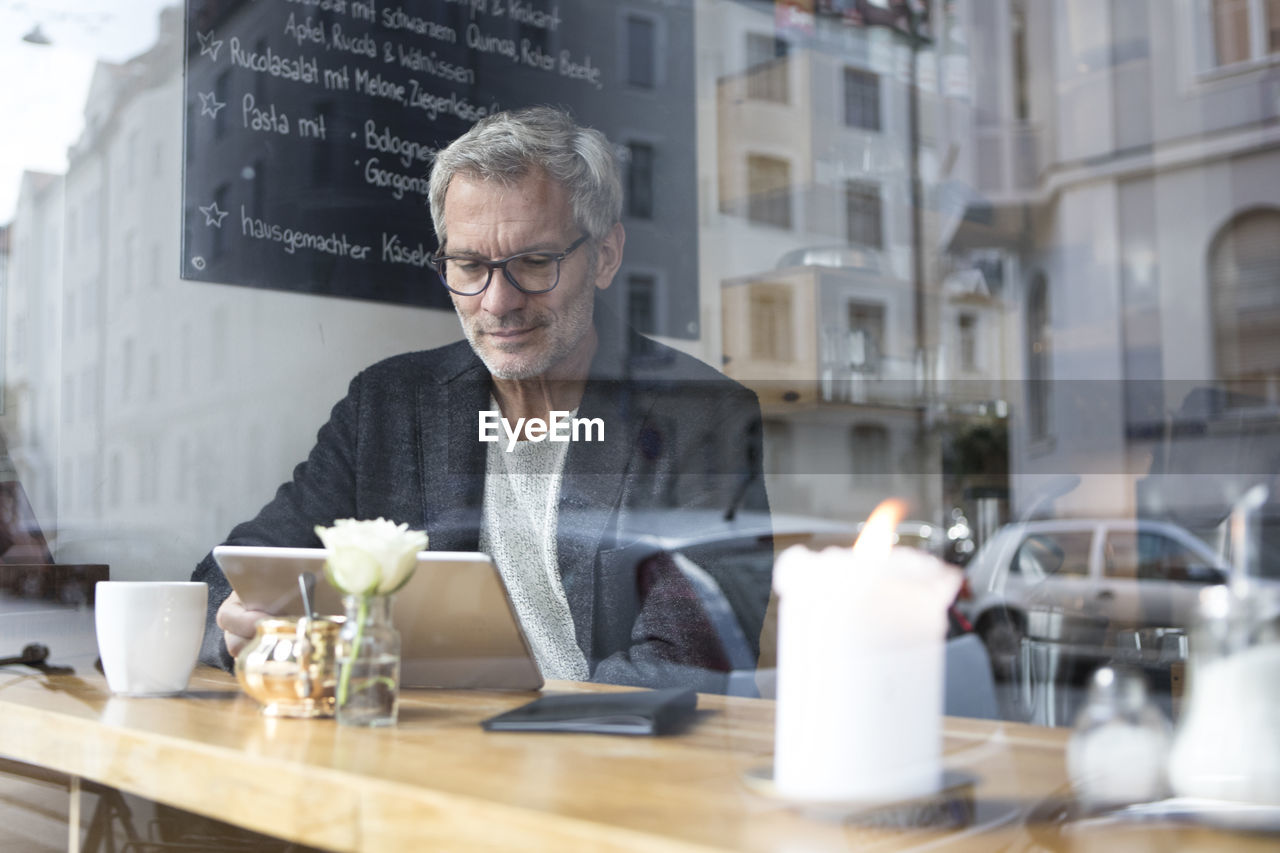 Mature man with tablet in a cafe