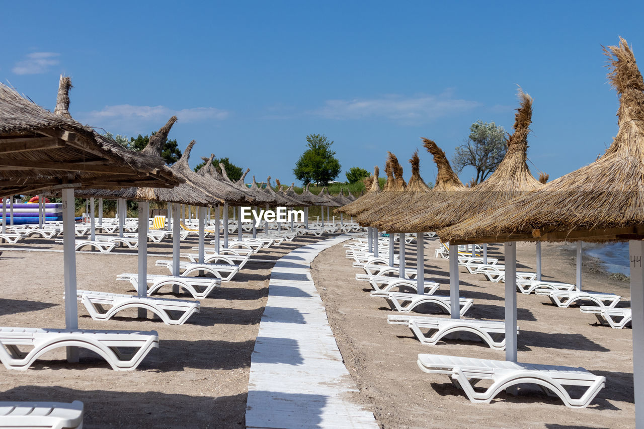 Sunbeds and umbrellas on the sandy beach, the summer season is ready for tourists