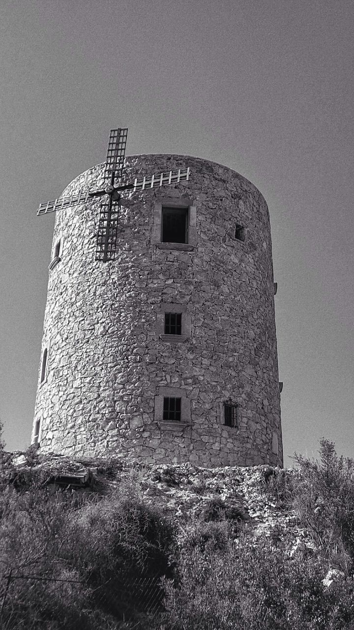 Low angle view of old windmill on hill