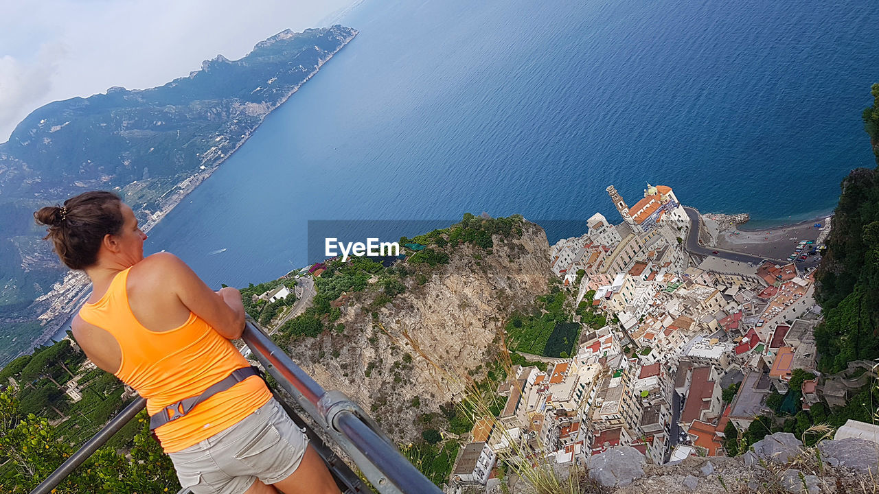 Rear view of mature woman looking at sea while standing on observation point