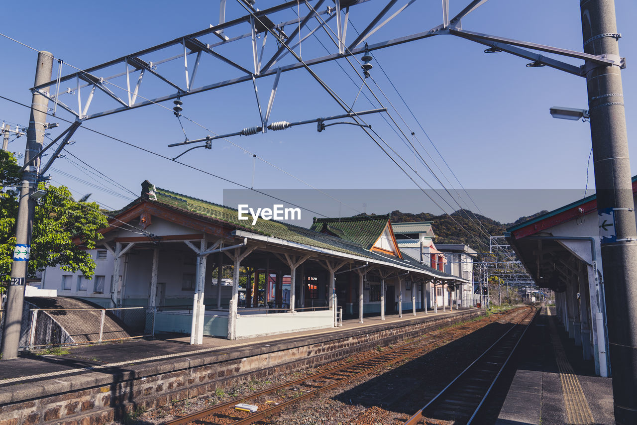 Railroad tracks by buildings against sky