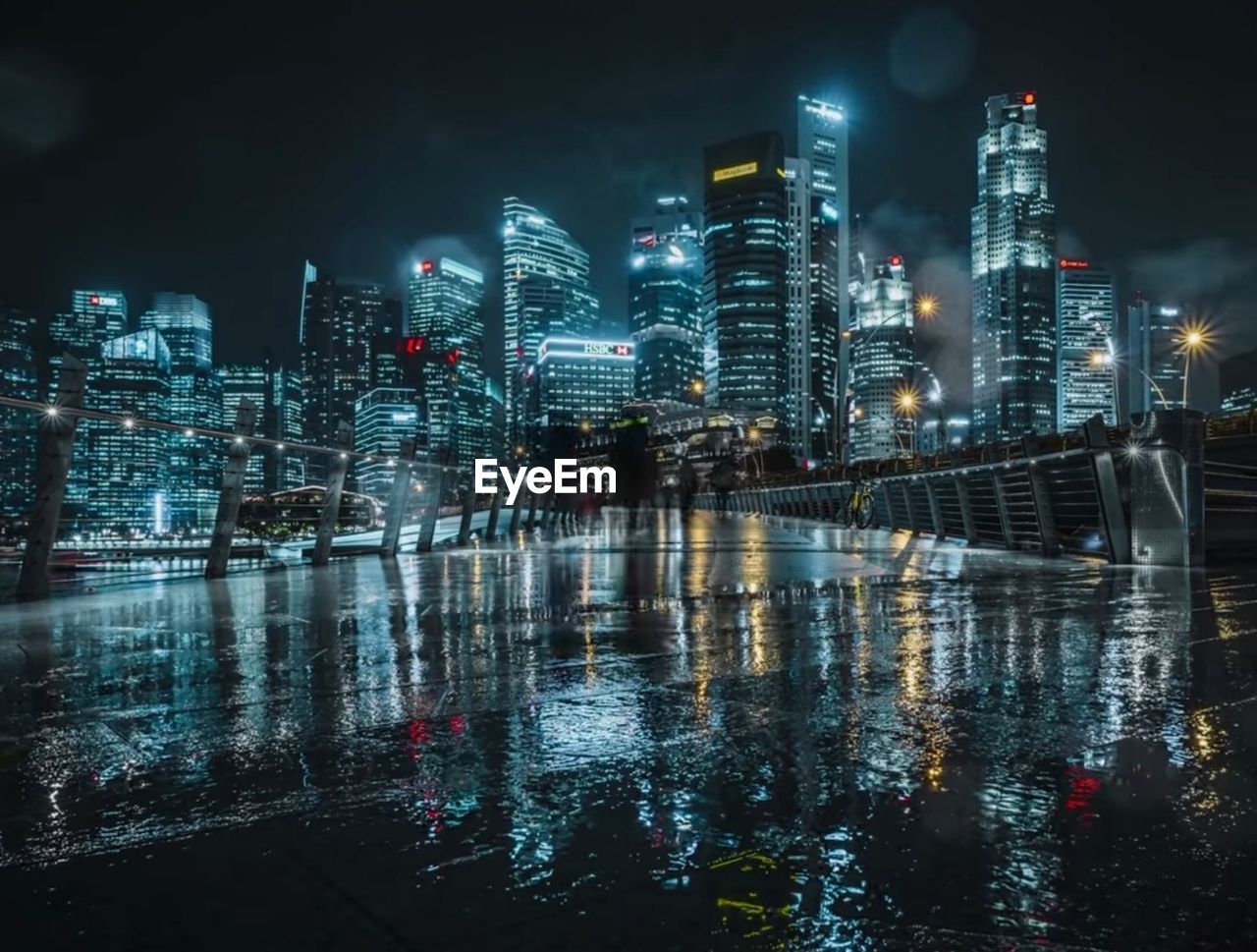 ILLUMINATED CITYSCAPE BY RIVER AT NIGHT