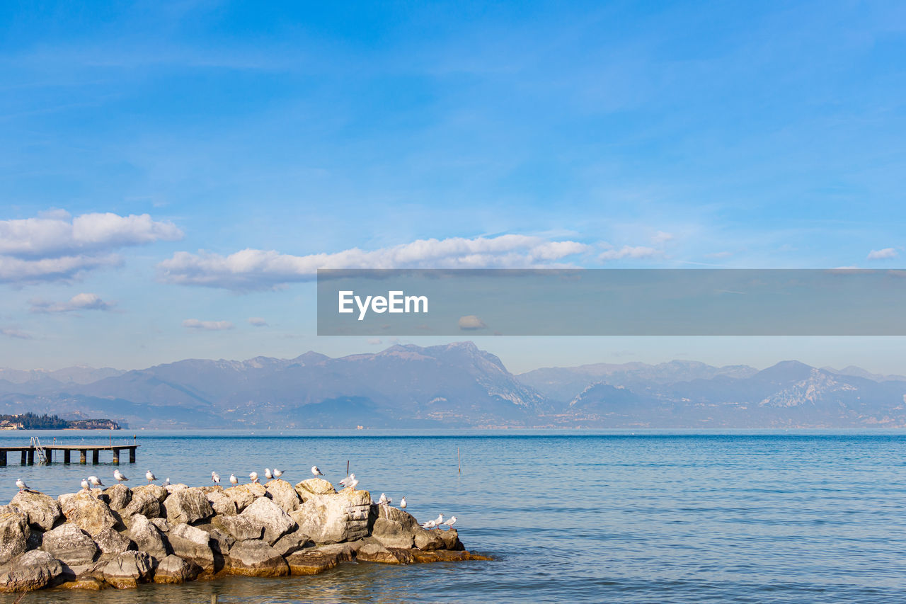 ROCKS IN SEA AGAINST SKY