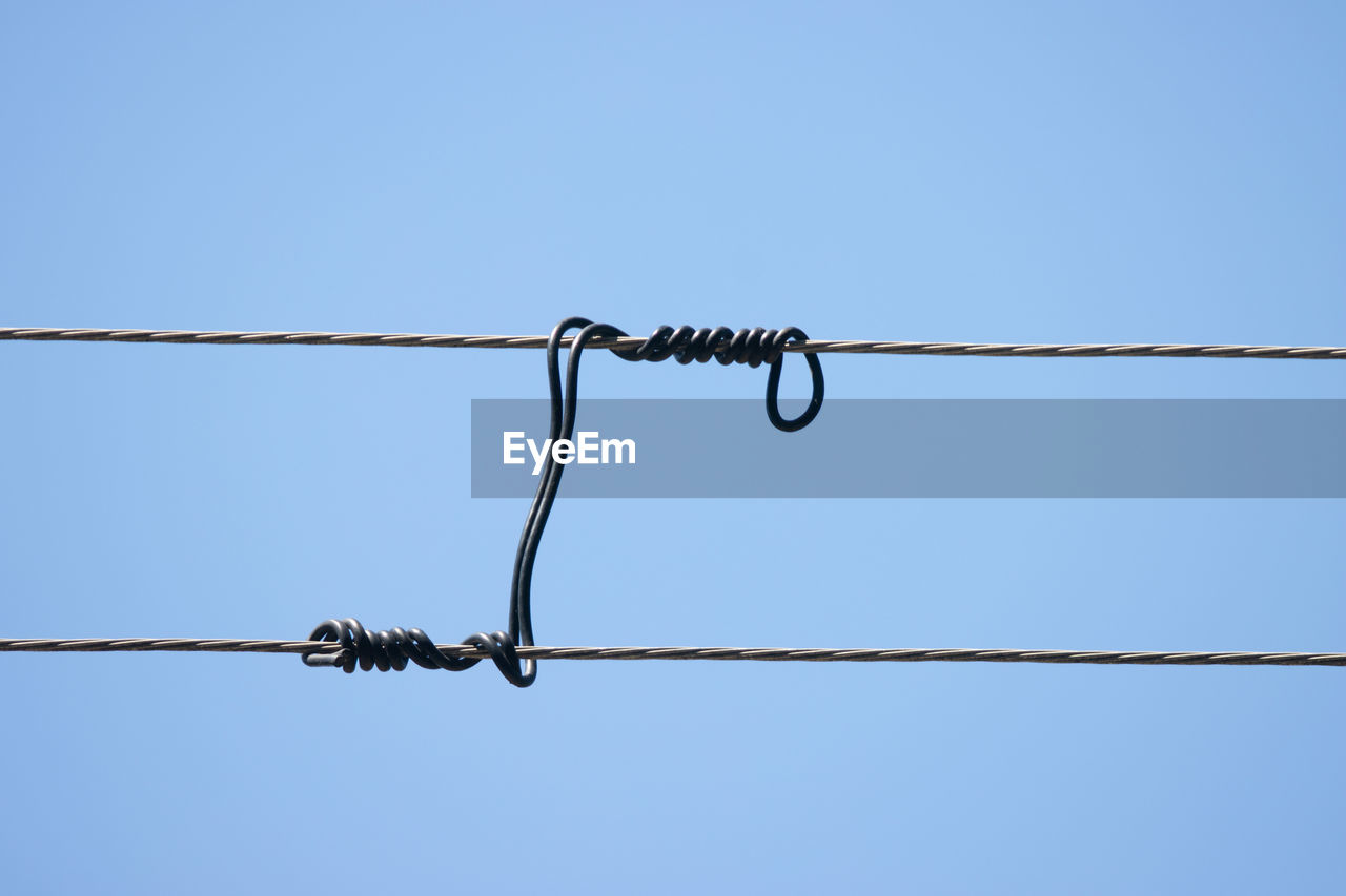 sky, clear sky, blue, cable, line, no people, wire, hanging, outdoor structure, fence, electricity, nature, metal, day, copy space, home fencing, power line, mast, communication, rope, low angle view, outdoors, wire fencing, telephone line, sunny, barbed wire, sign, technology, power supply