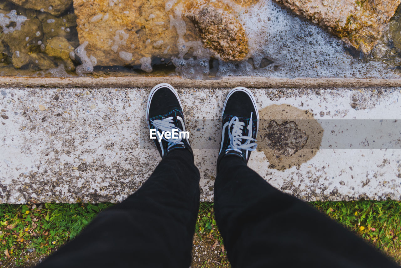 LOW SECTION OF PERSON STANDING ON ROCK