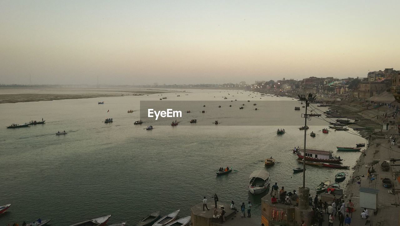 HIGH ANGLE VIEW OF BIRDS ON BEACH AGAINST SKY