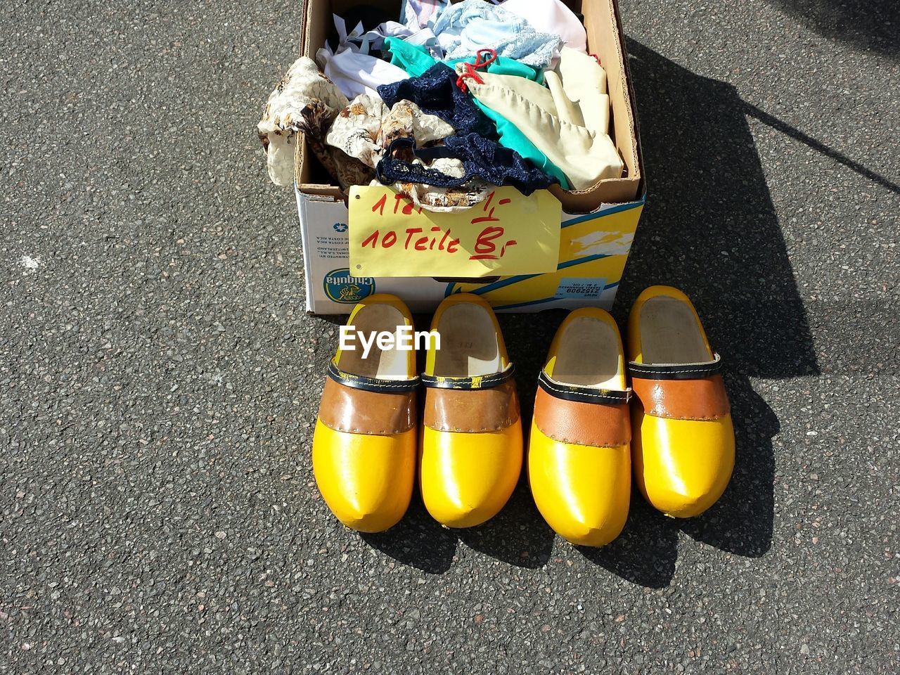 High angle view of shoes and clothes in box on street
