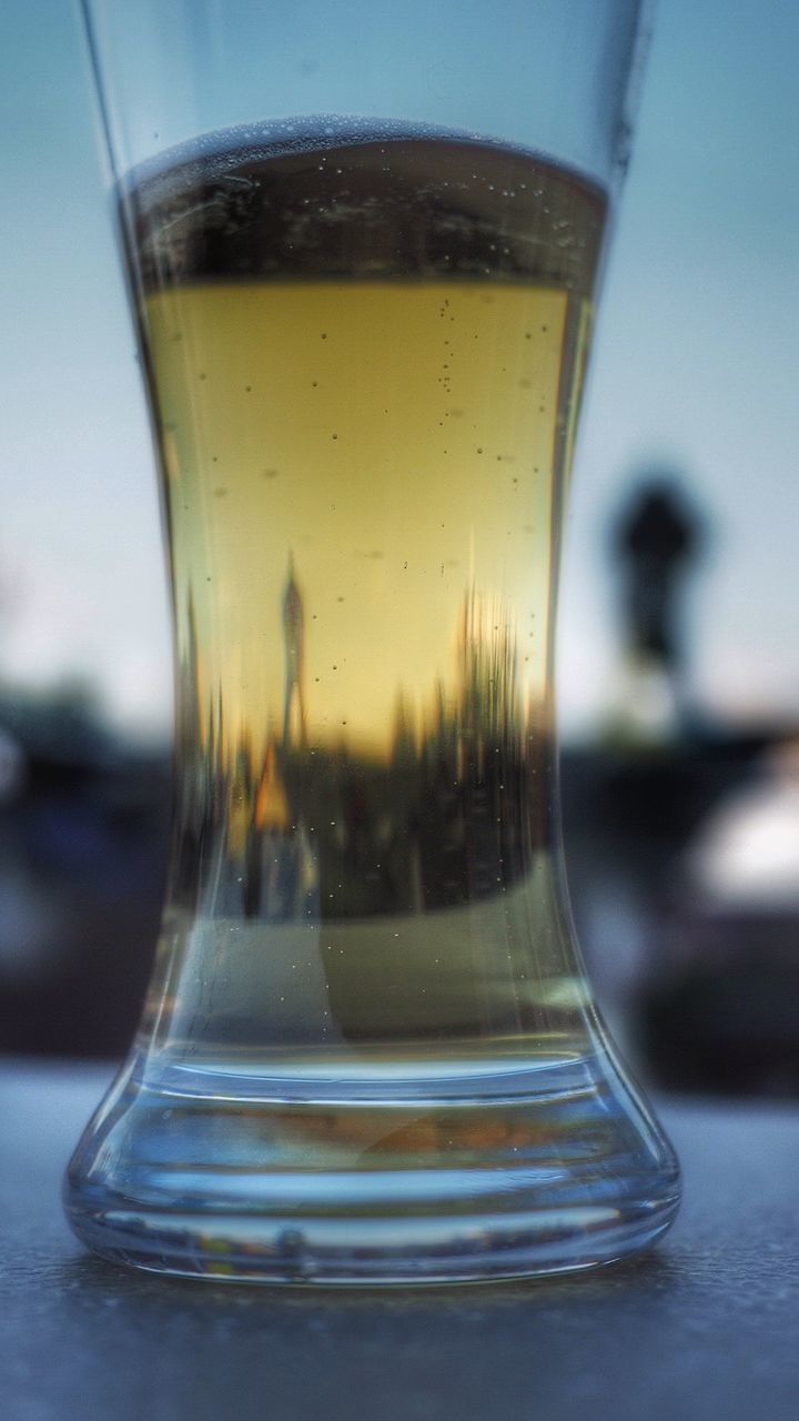 Close-up of water in glass against sky