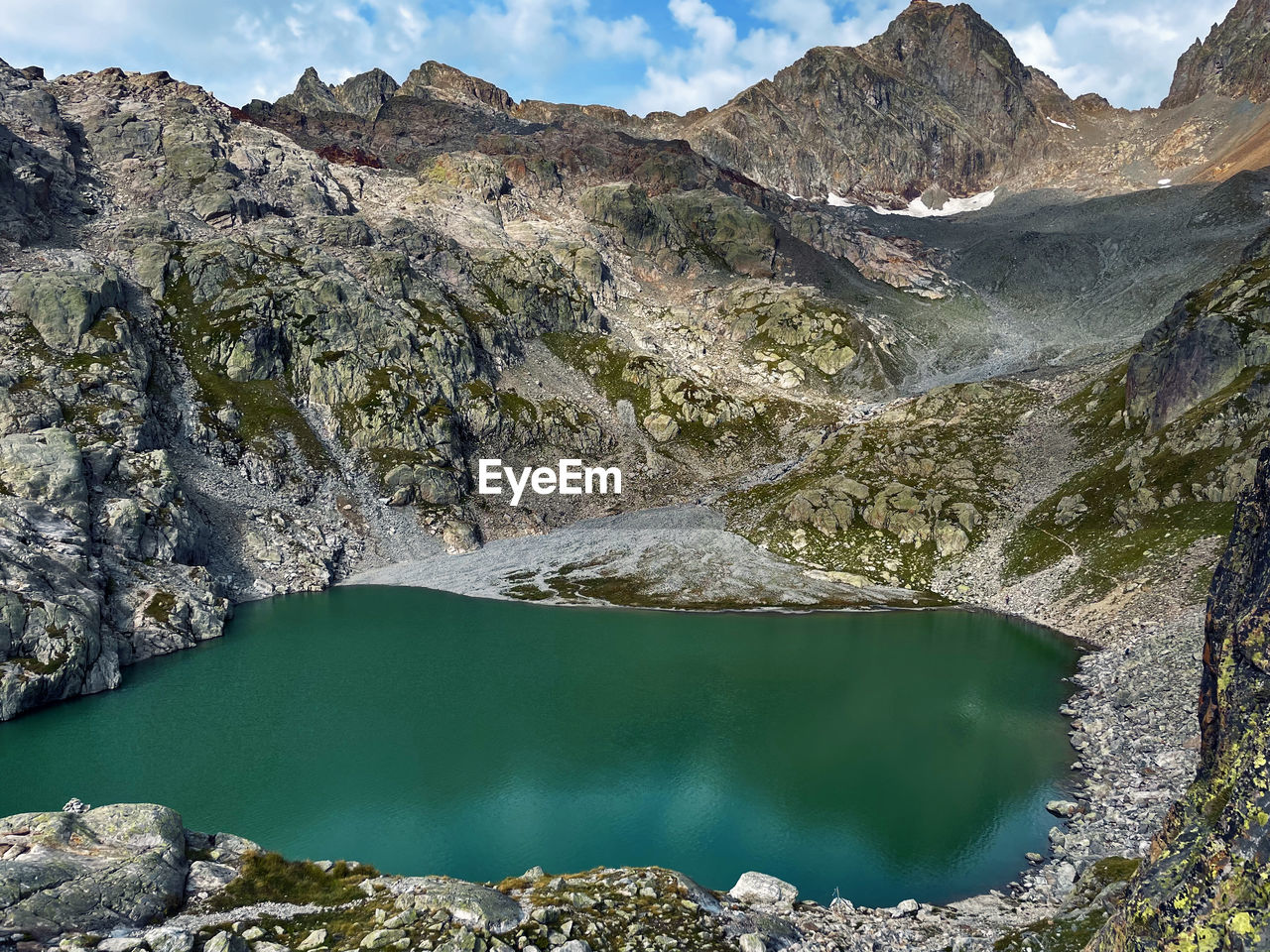 mountain, water, scenics - nature, environment, landscape, lake, wilderness, beauty in nature, nature, mountain range, sky, land, rock, travel destinations, crater lake, activity, cloud, hiking, travel, tranquility, non-urban scene, leisure activity, tranquil scene, geology, pine tree, outdoors, coniferous tree, pinaceae, mountain pass, tourism, reflection, blue, mountain peak, plant, walking, day, social issues, forest, valley, tree, adventure, pine woodland, glacial lake, ridge, moraine, physical geography, extreme terrain, idyllic