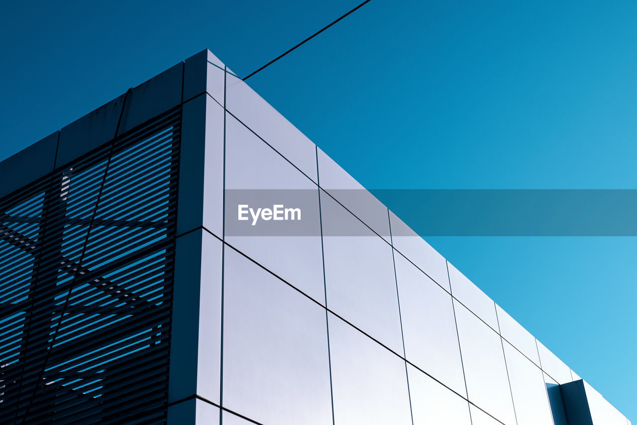 Low angle view of modern building against clear blue sky