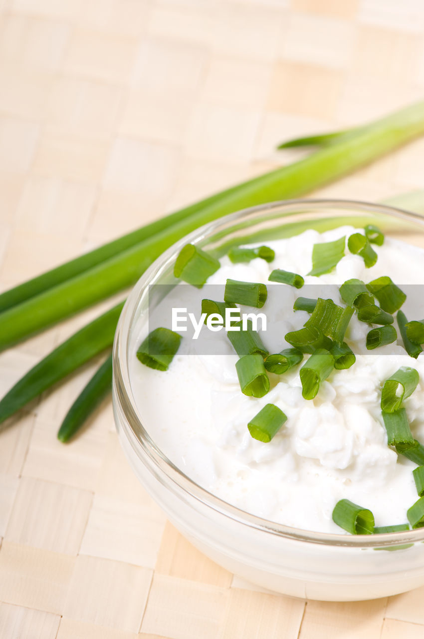 Close-up of chive slices in cottage cheese on table