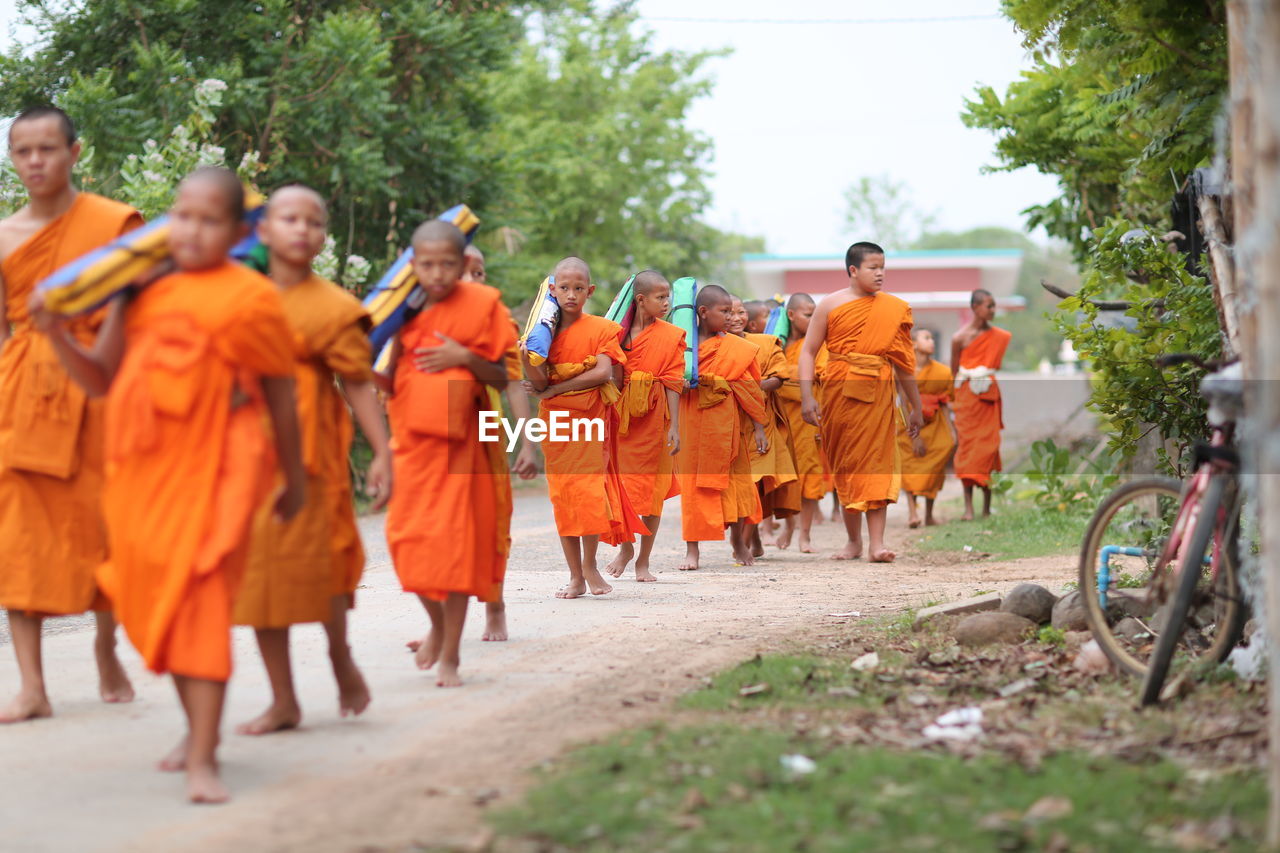 REAR VIEW OF PEOPLE WALKING IN ROW