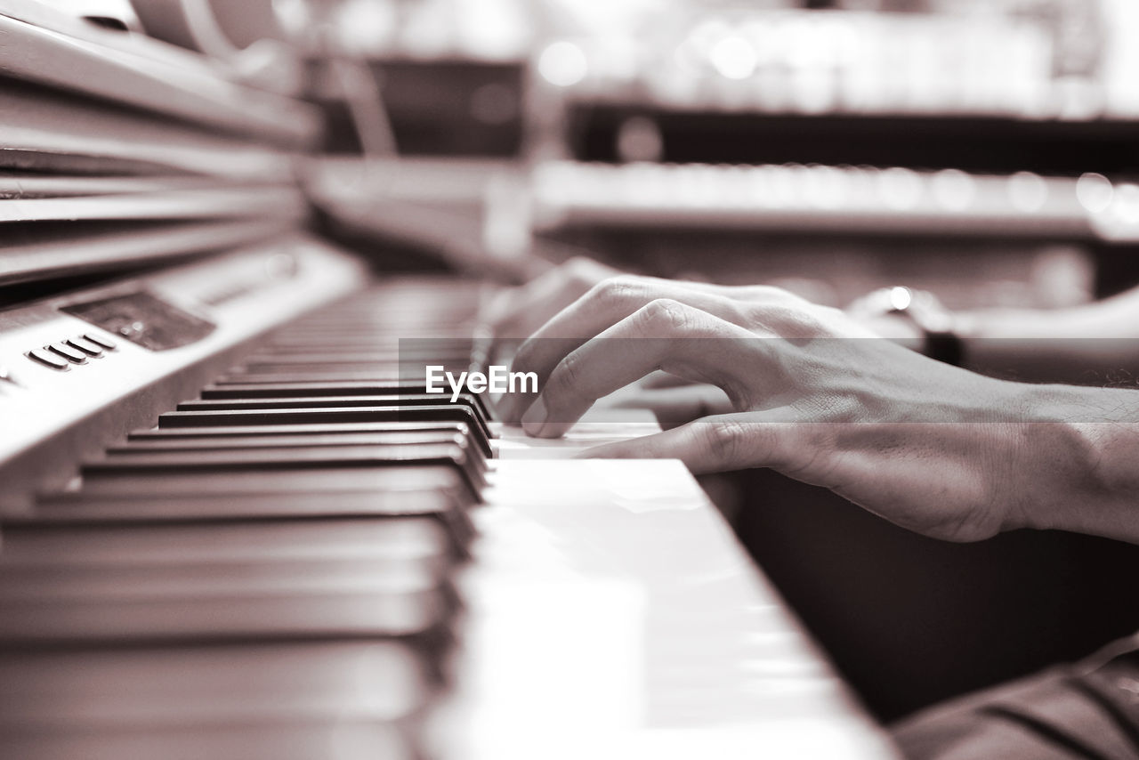 Cropped image of person playing piano