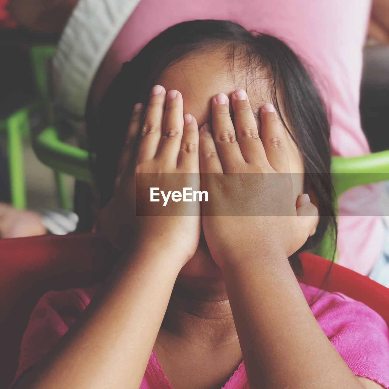 Close-up of girl covering face with hand