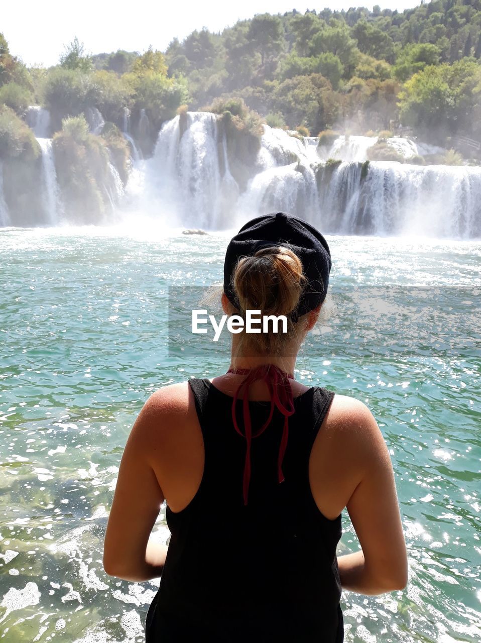 Rear view of woman looking at waterfall