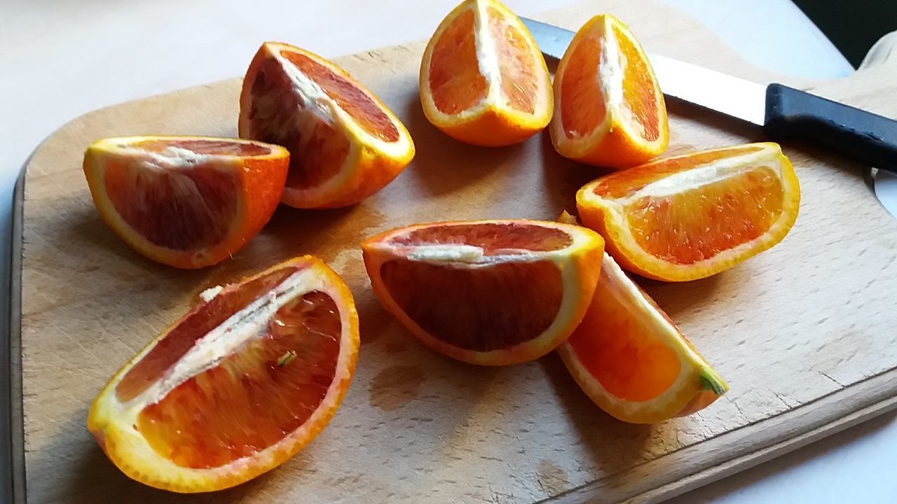 CLOSE-UP OF ORANGE SLICES WITH FRUITS ON TABLE