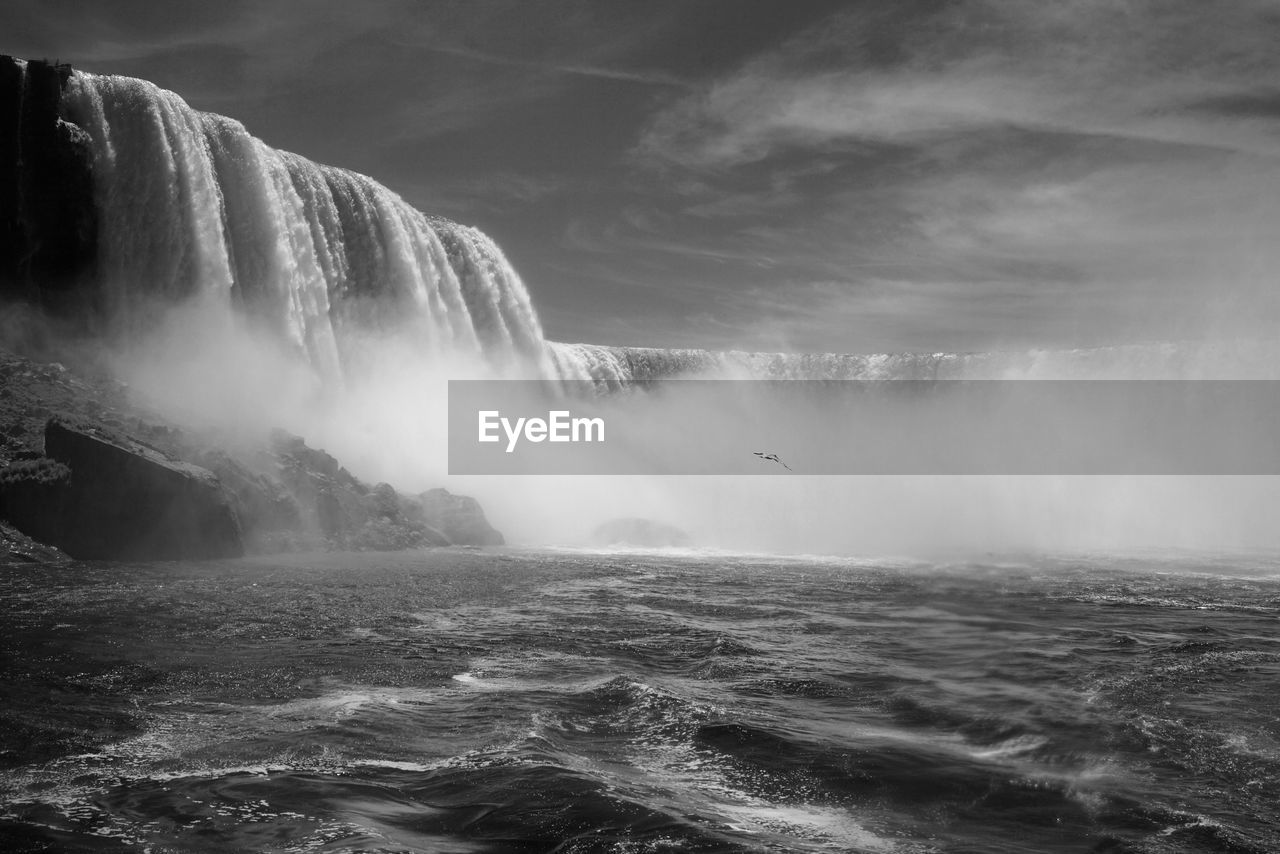 Scenic view of waterfall against sky