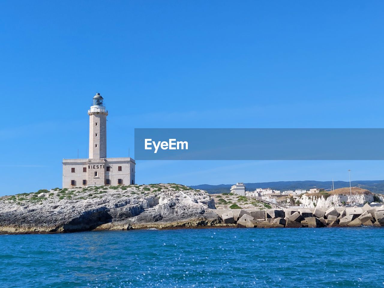 LIGHTHOUSE BY SEA AGAINST SKY