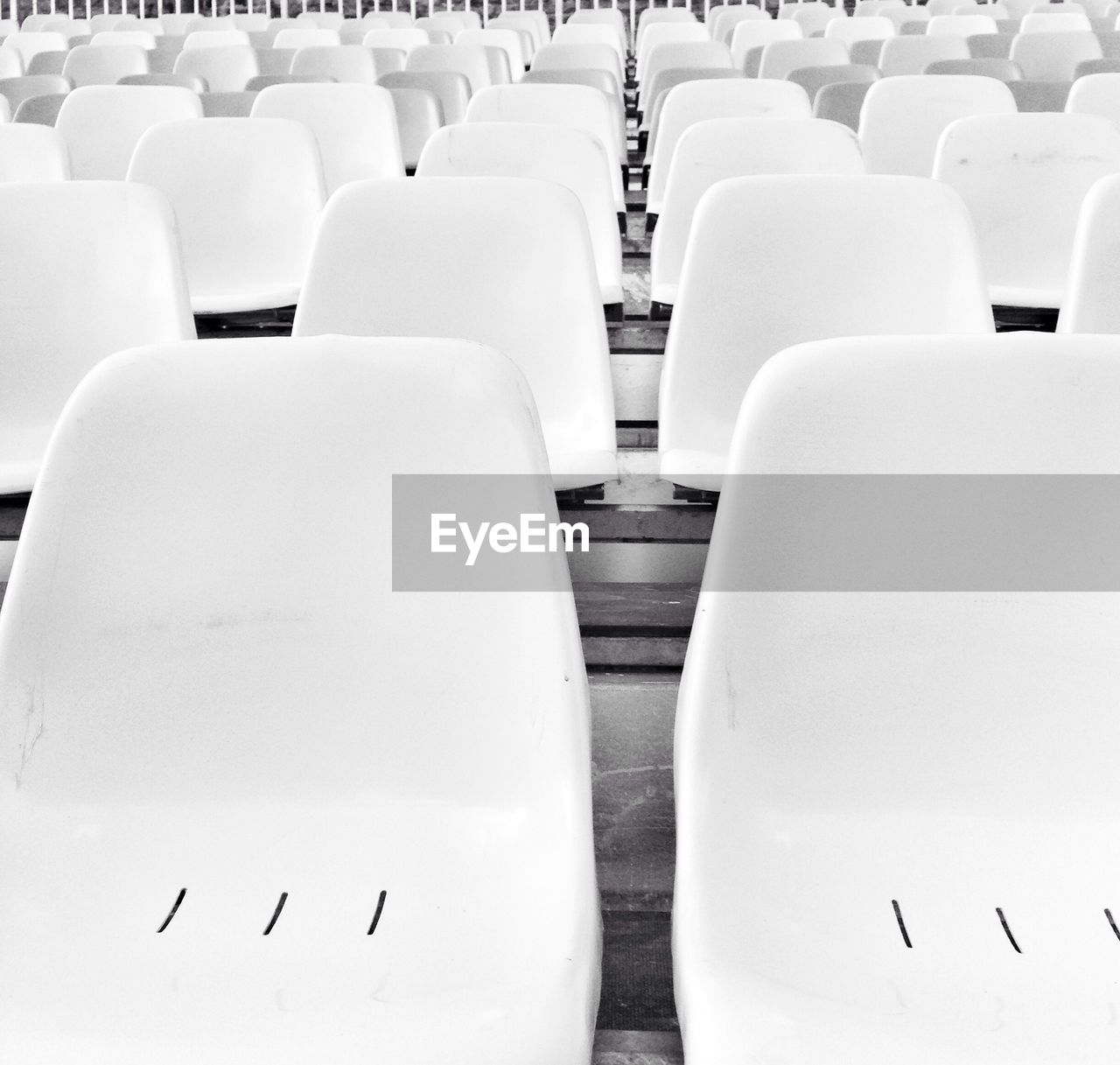 Close-up of white chairs in auditorium