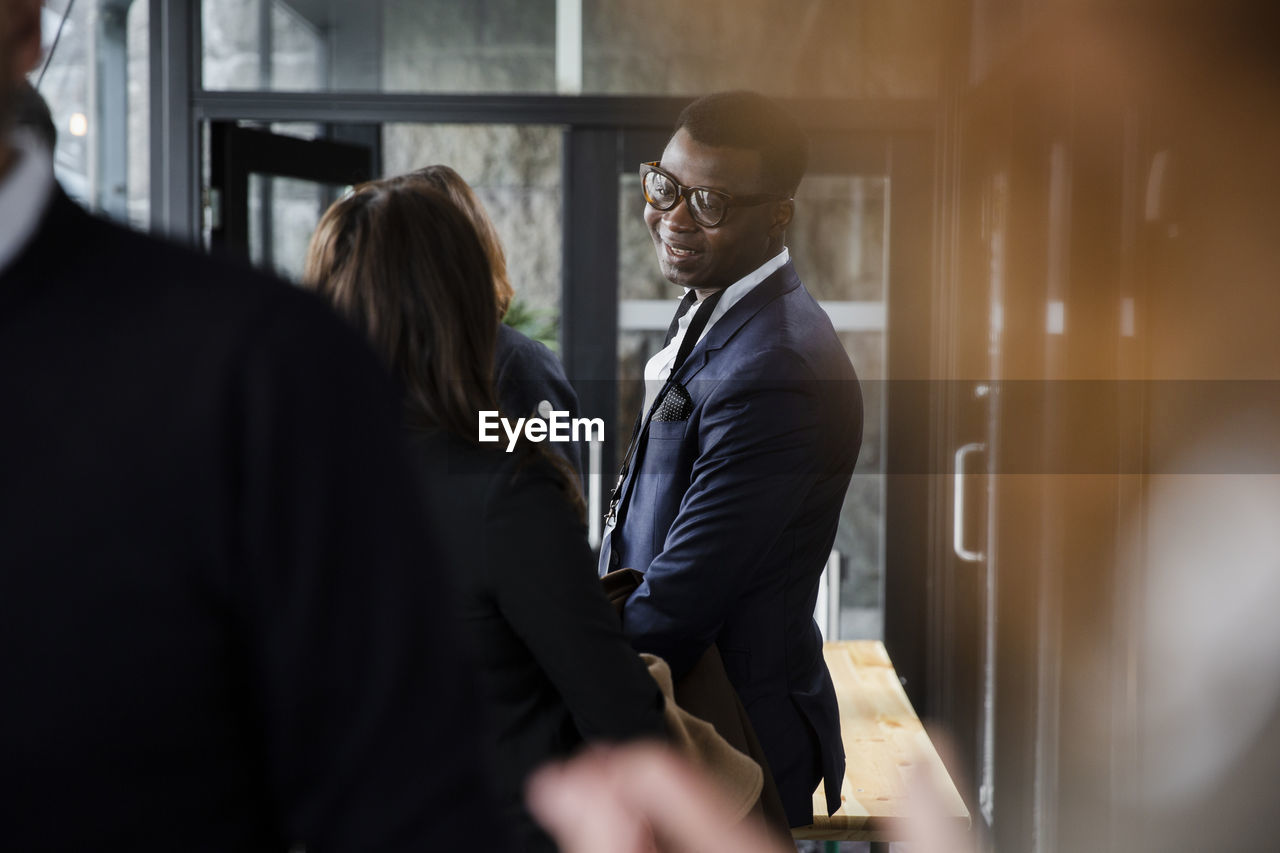 Side view of businessman talking to female delegate at conference center