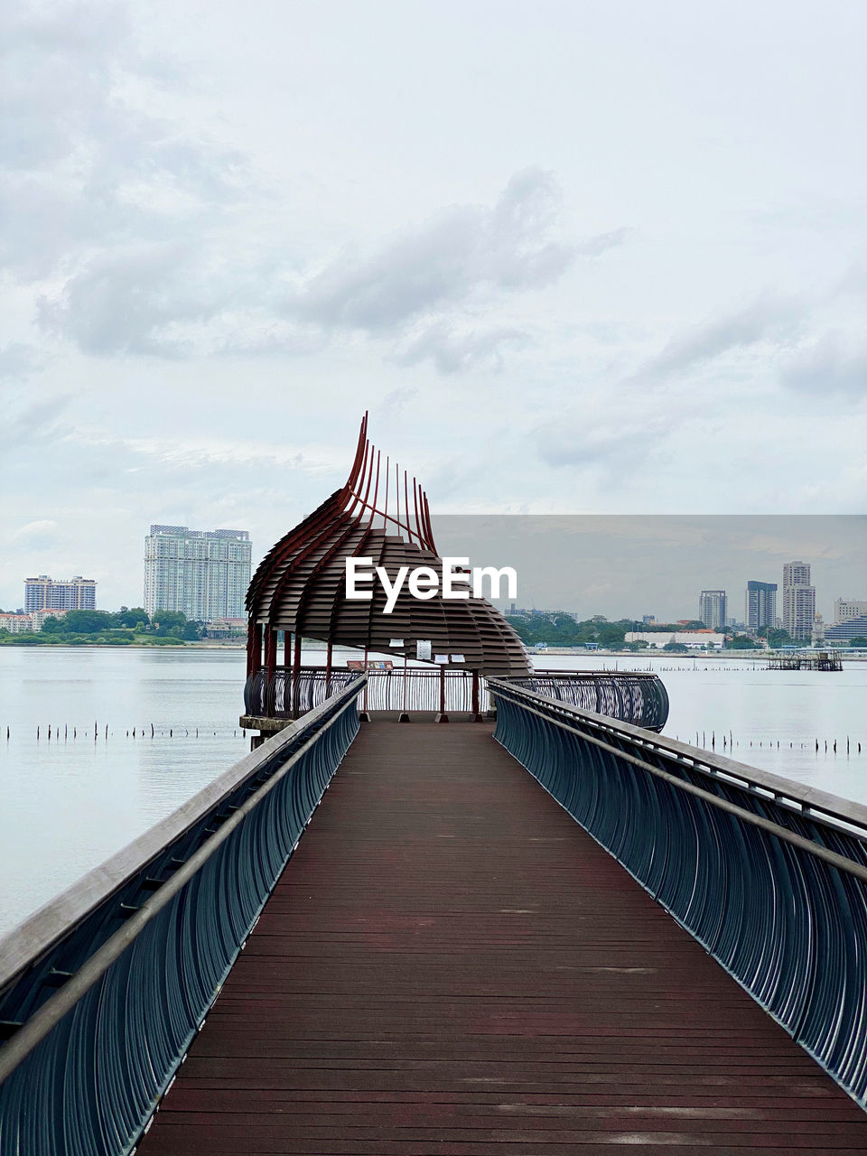 Footbridge over river with buildings in background