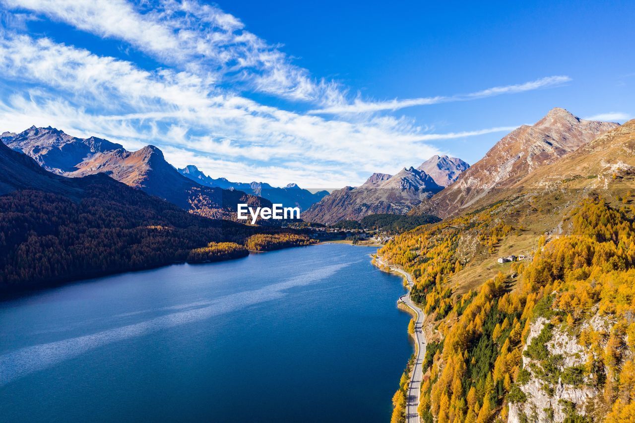 Scenic view of lake and mountains against blue sky