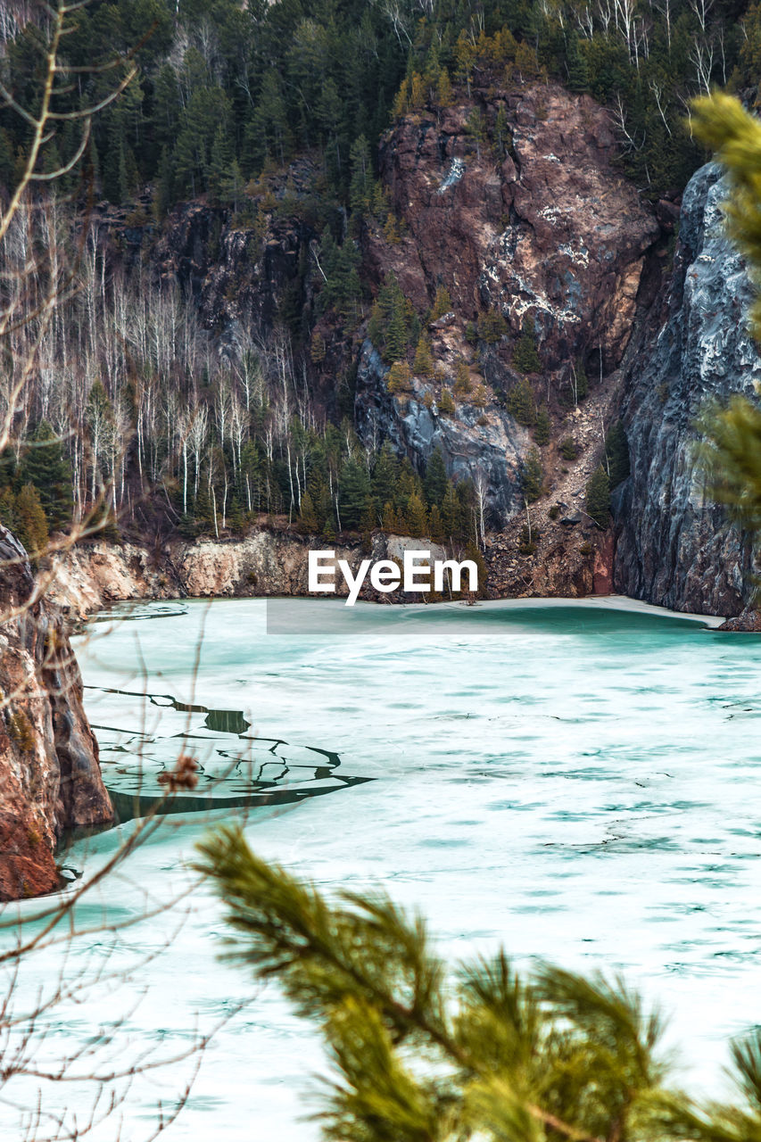 Frozen lake against rocky mountain