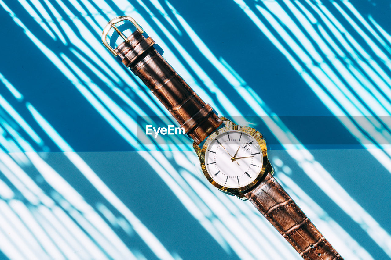 Gold watch on a blue background.