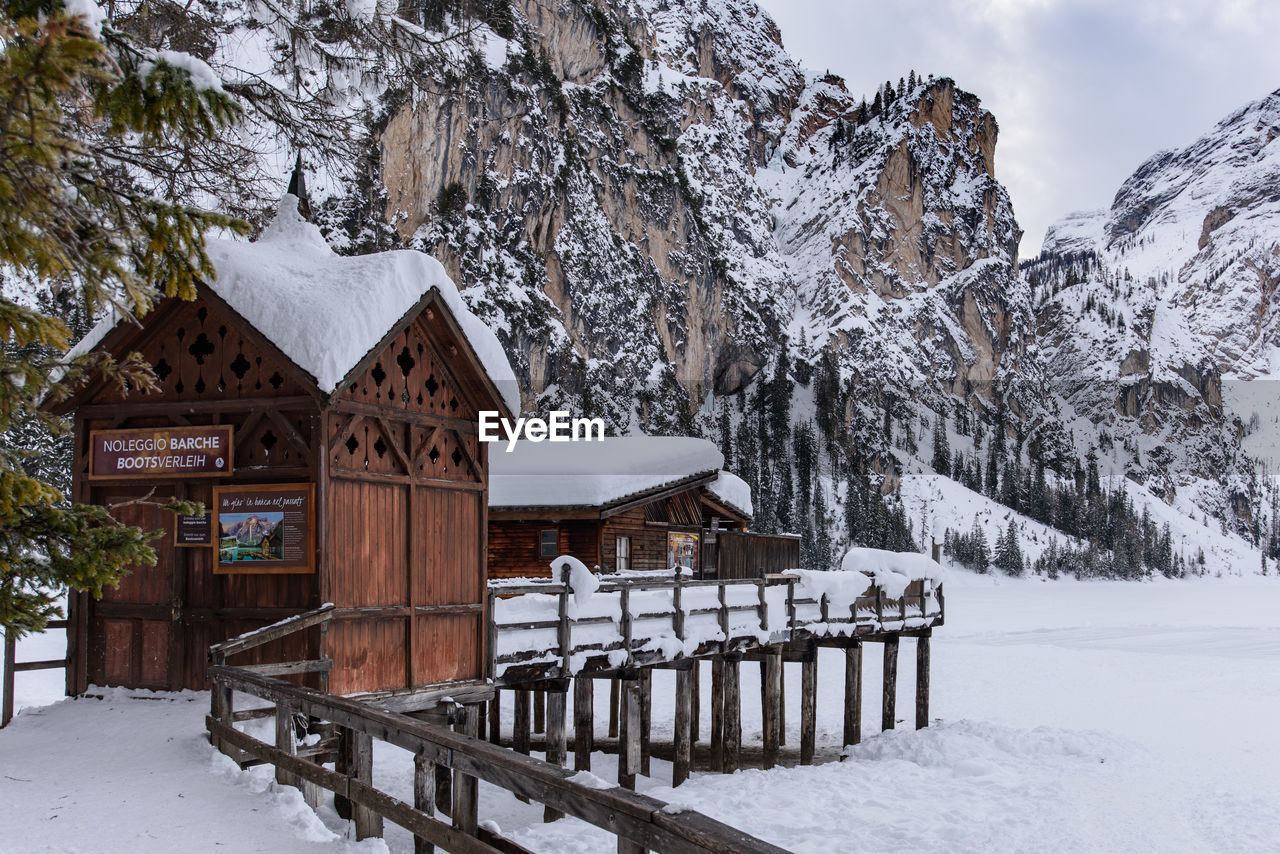 BUILT STRUCTURE ON SNOW COVERED HOUSES AGAINST SKY