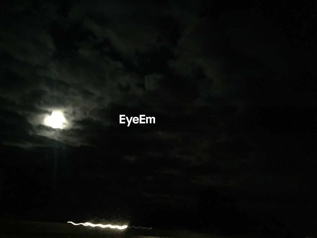 LOW ANGLE VIEW OF ILLUMINATED MOON IN SKY