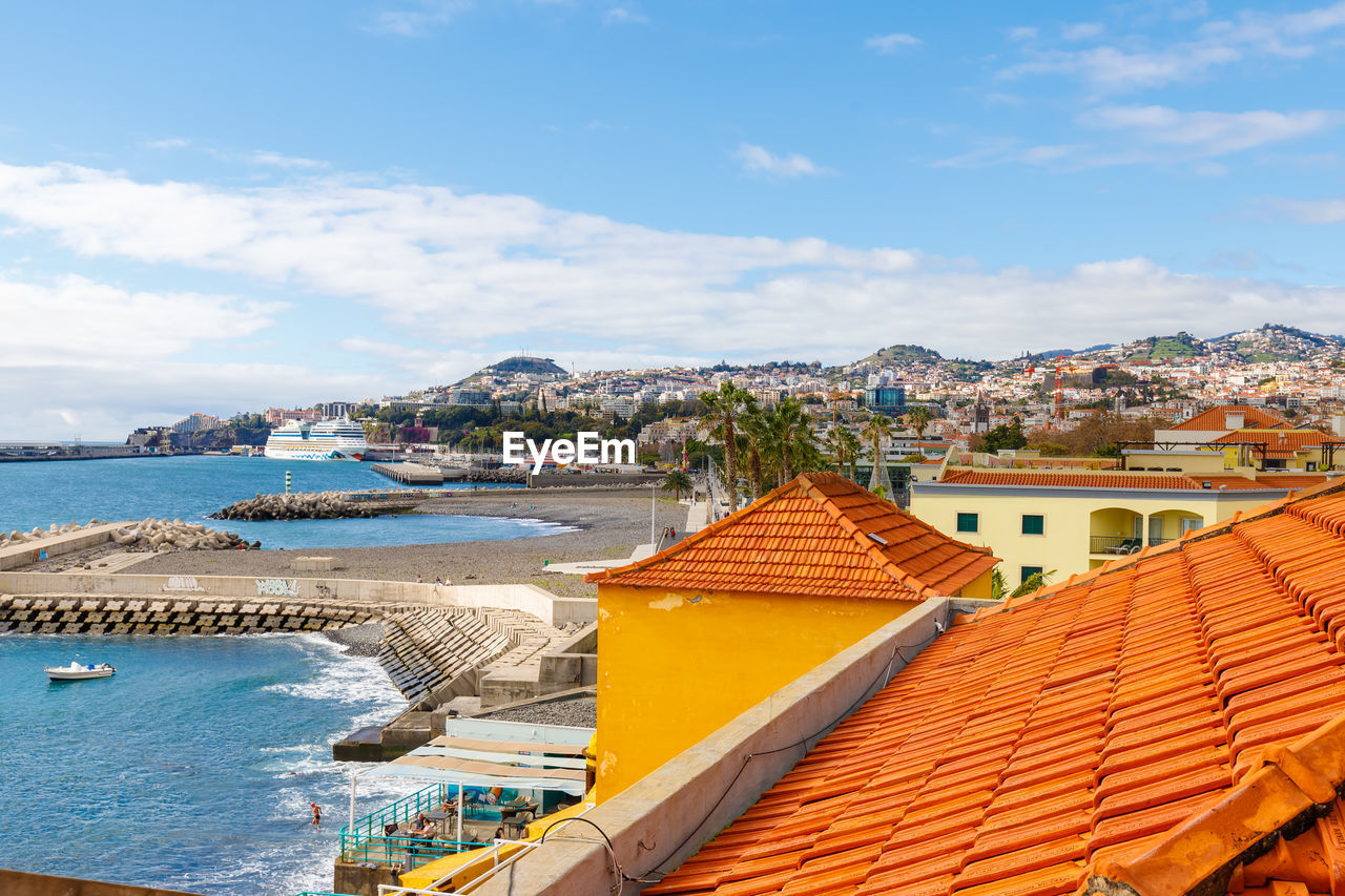 water, architecture, vacation, sea, building exterior, built structure, sky, building, land, nature, travel destinations, roof, beach, city, house, cloud, travel, coast, tourism, residential district, day, no people, nautical vessel, outdoors, high angle view, trip, holiday, scenics - nature, blue, town, beauty in nature, coastline, transportation, harbor, roof tile, sunlight, cityscape, tourist resort, summer, environment